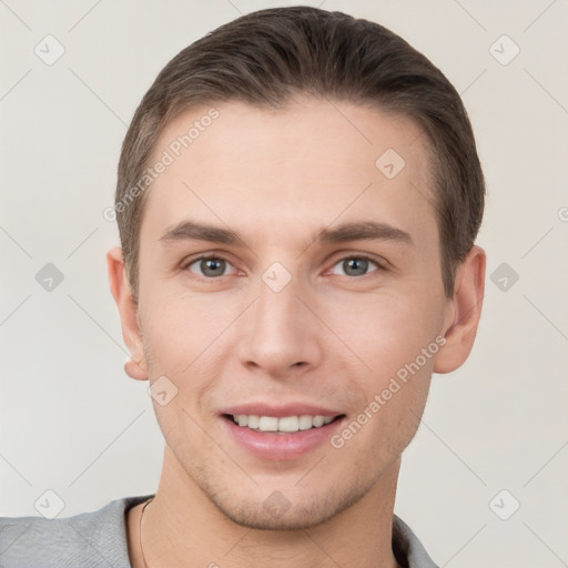 Joyful white young-adult male with short  brown hair and grey eyes