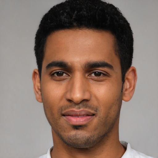 Joyful latino young-adult male with short  black hair and brown eyes