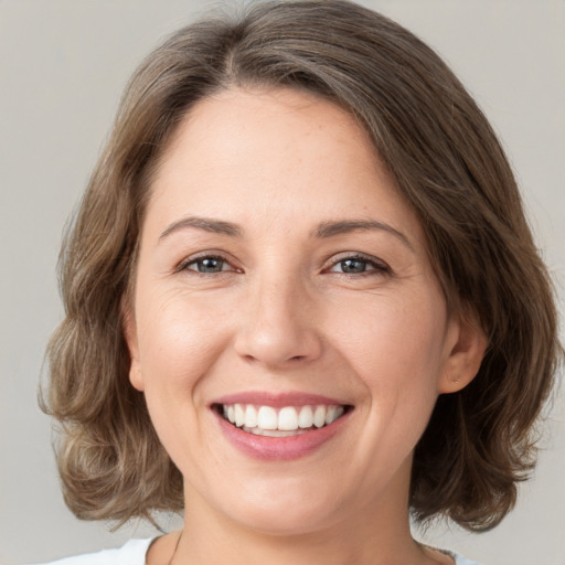 Joyful white young-adult female with medium  brown hair and brown eyes