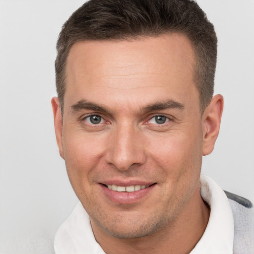 Joyful white adult male with short  brown hair and brown eyes