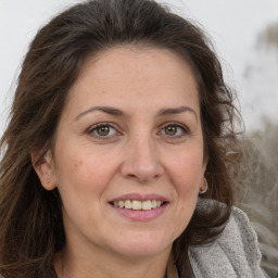 Joyful white adult female with long  brown hair and brown eyes