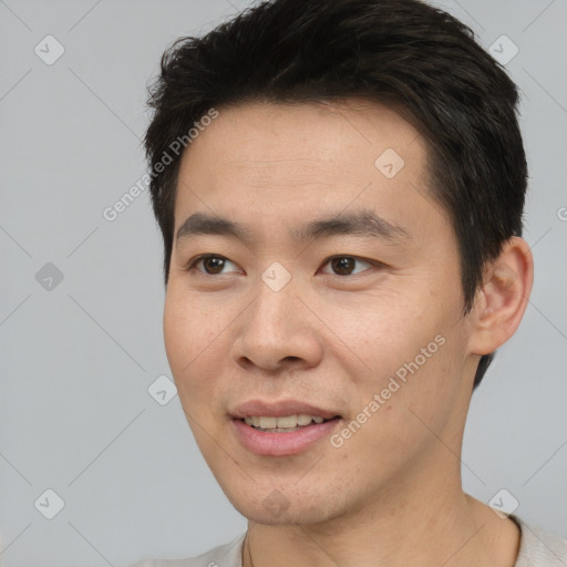 Joyful asian young-adult male with short  brown hair and brown eyes