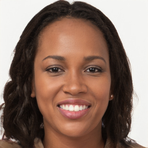 Joyful black young-adult female with long  brown hair and brown eyes