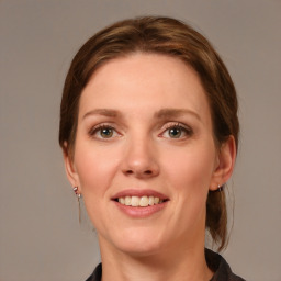 Joyful white young-adult female with medium  brown hair and grey eyes