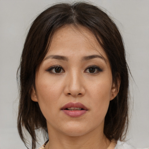 Joyful asian young-adult female with medium  brown hair and brown eyes