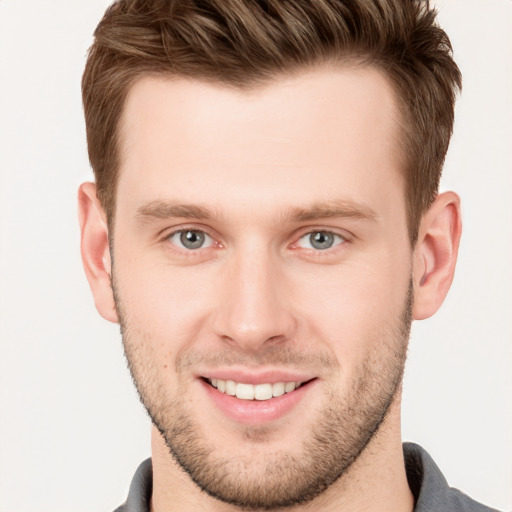 Joyful white young-adult male with short  brown hair and grey eyes