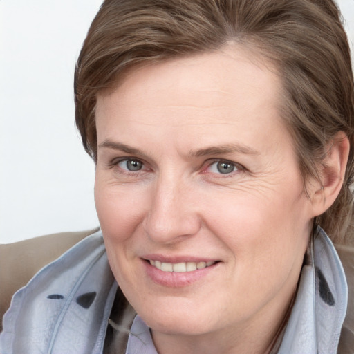 Joyful white adult female with medium  brown hair and grey eyes