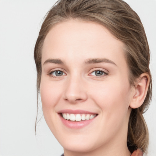 Joyful white young-adult female with medium  brown hair and blue eyes