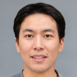 Joyful asian young-adult male with short  brown hair and brown eyes