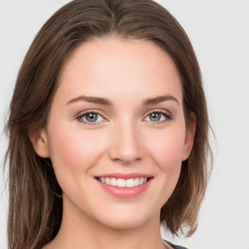 Joyful white young-adult female with long  brown hair and green eyes