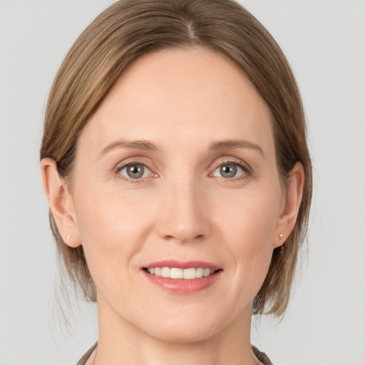 Joyful white young-adult female with medium  brown hair and grey eyes