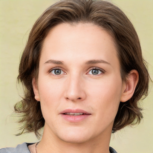 Joyful white young-adult female with medium  brown hair and green eyes