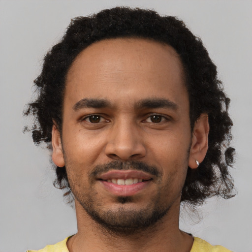 Joyful black young-adult male with short  black hair and brown eyes