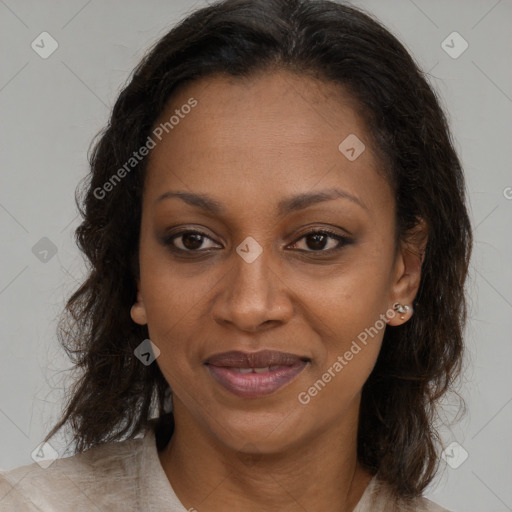 Joyful black adult female with long  brown hair and brown eyes