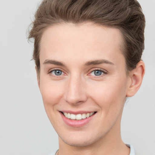 Joyful white young-adult female with short  brown hair and grey eyes