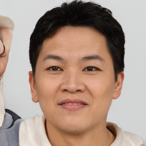 Joyful asian young-adult male with short  brown hair and brown eyes