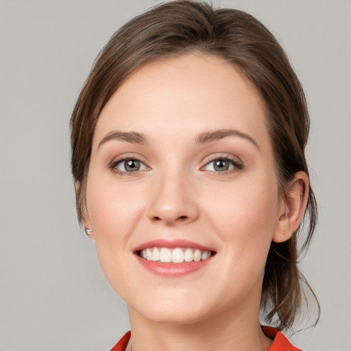 Joyful white young-adult female with medium  brown hair and grey eyes