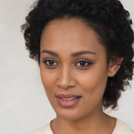 Joyful black young-adult female with long  brown hair and brown eyes