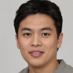 Joyful asian young-adult male with short  black hair and brown eyes