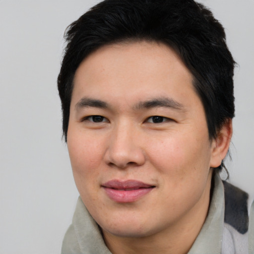 Joyful asian young-adult male with short  brown hair and brown eyes