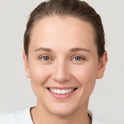 Joyful white young-adult female with short  brown hair and grey eyes