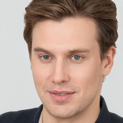 Joyful white young-adult male with short  brown hair and grey eyes