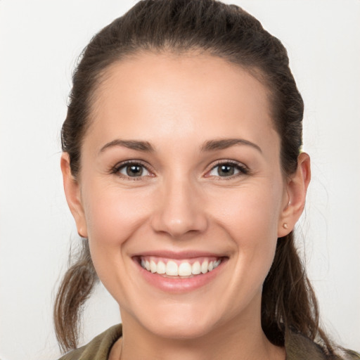 Joyful white young-adult female with long  brown hair and brown eyes