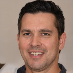 Joyful white adult male with short  brown hair and brown eyes