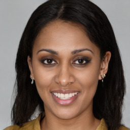 Joyful latino young-adult female with long  brown hair and brown eyes