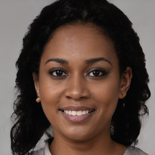 Joyful black young-adult female with medium  black hair and brown eyes