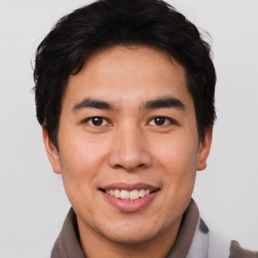 Joyful asian young-adult male with short  brown hair and brown eyes