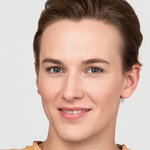 Joyful white young-adult female with short  brown hair and grey eyes