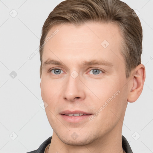 Joyful white young-adult male with short  brown hair and grey eyes