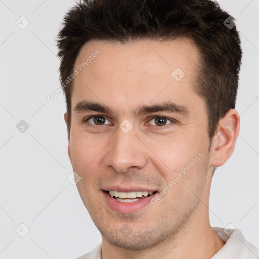 Joyful white young-adult male with short  brown hair and brown eyes