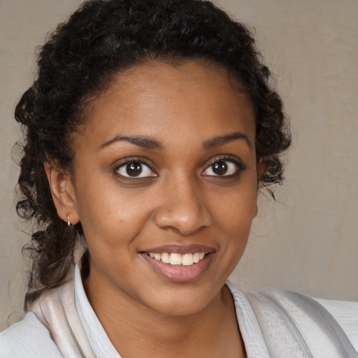 Joyful black young-adult female with medium  brown hair and brown eyes