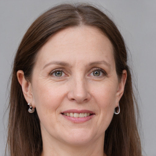 Joyful white adult female with long  brown hair and grey eyes