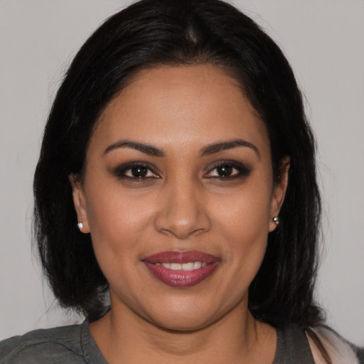 Joyful latino young-adult female with medium  black hair and brown eyes