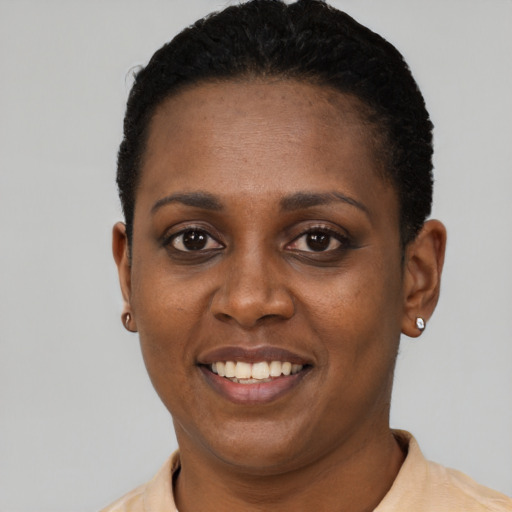 Joyful black young-adult female with short  black hair and brown eyes