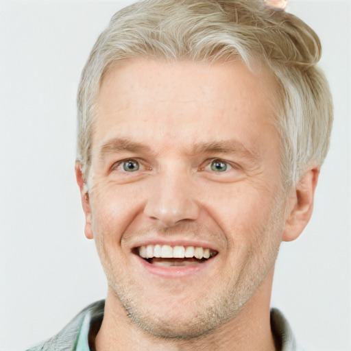 Joyful white adult male with short  blond hair and grey eyes