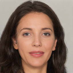 Joyful white adult female with long  brown hair and brown eyes