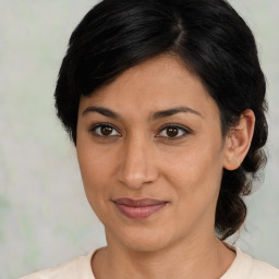 Joyful latino adult female with medium  brown hair and brown eyes