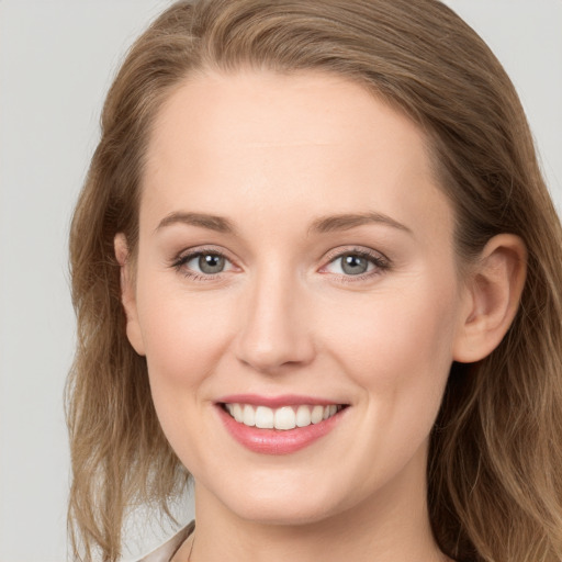 Joyful white young-adult female with long  brown hair and grey eyes