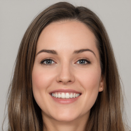 Joyful white young-adult female with long  brown hair and grey eyes