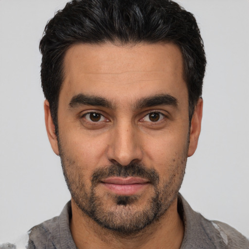 Joyful white young-adult male with short  black hair and brown eyes