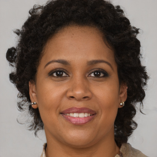 Joyful black adult female with medium  brown hair and brown eyes