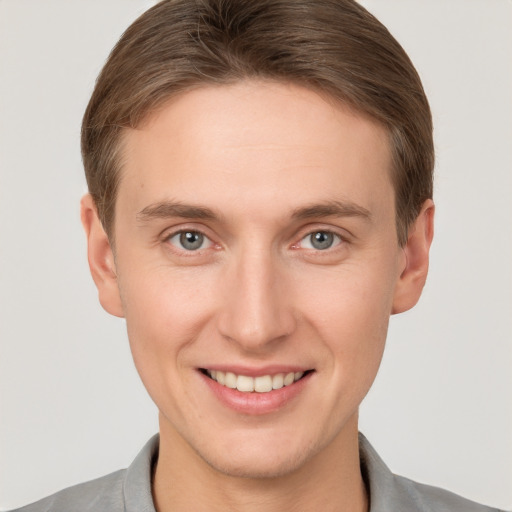 Joyful white young-adult male with short  brown hair and grey eyes