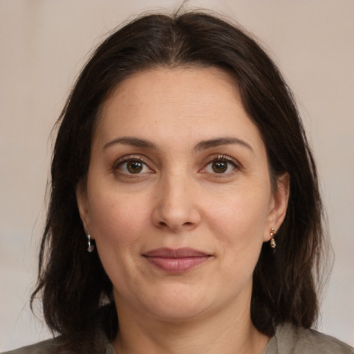 Joyful white adult female with medium  brown hair and brown eyes