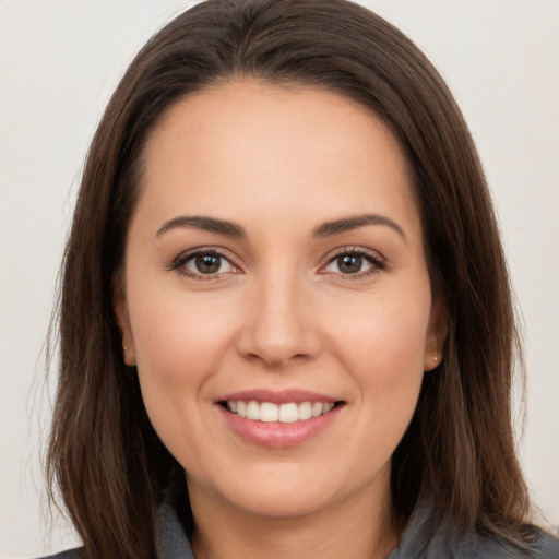 Joyful white young-adult female with long  brown hair and brown eyes