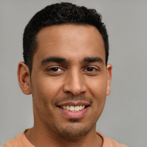 Joyful latino young-adult male with short  brown hair and brown eyes