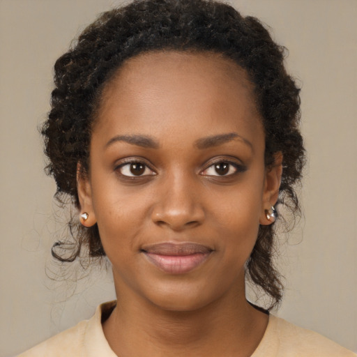 Joyful black young-adult female with long  brown hair and brown eyes